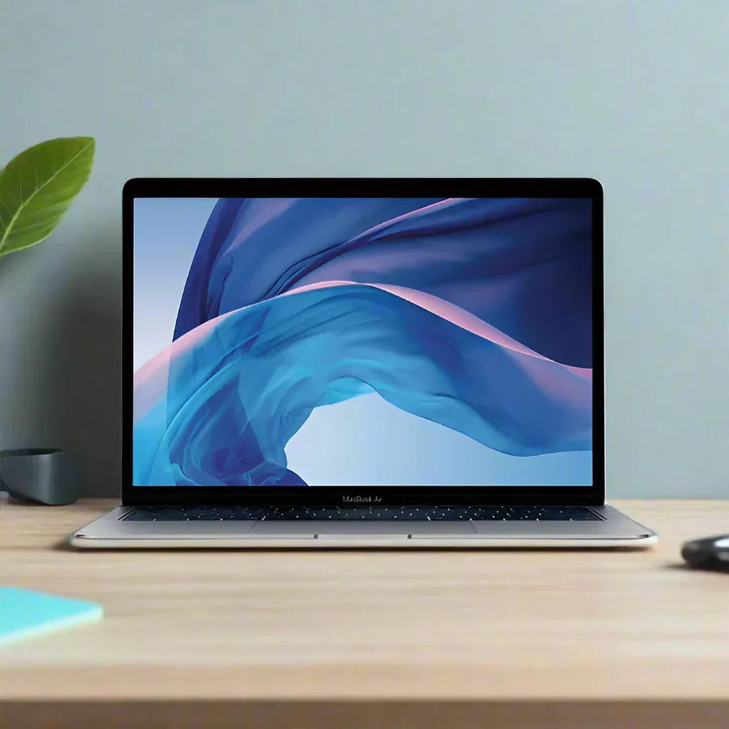 A certified refurbished Apple MacBook Air 2018 A1932 with i5 1.6GHz, 8GB RAM, and 256GB sits on a wooden desk, its Retina display showing blue and purple waves. A green plant and small cup are visible against a light gray wall in the background.