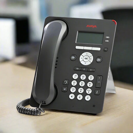 A certified refurbished Avaya 9608G IP Telephone (Part ID: 700419195) with handset and stand by Avaya sits on a light wooden surface. It features a digital display, keypad, and coiled cord—ideal for upgrading your office communications.