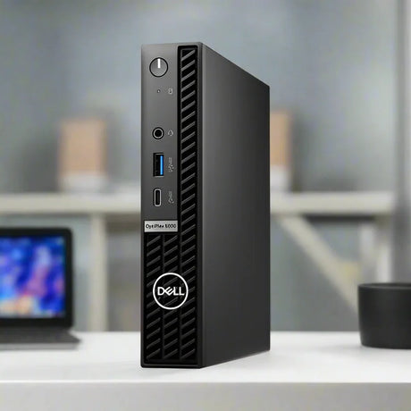 A black Dell OptiPlex 5000 Micro i5 12500T business desktop stands vertically, showing its front panel with power button, USB ports, headphone jack, ventilation grille, and Dell logo. Specs: 16GB RAM, 256GB SSD, WiFi, Windows 11 Pro.