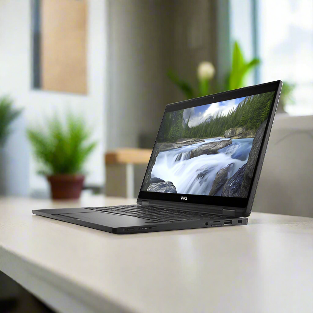 A certified refurbished Dell Latitude 7389 2-in-1 i5 7300U laptop is open on a light desk, displaying a scenic river. Potted green plants brighten the softly blurred room in the background.