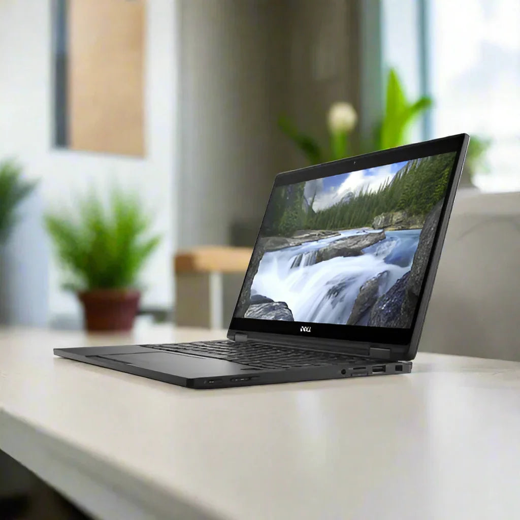 A certified refurbished Dell Latitude 7389 2-in-1 i5 7300U laptop is open on a light desk, displaying a scenic river. Potted green plants brighten the softly blurred room in the background.