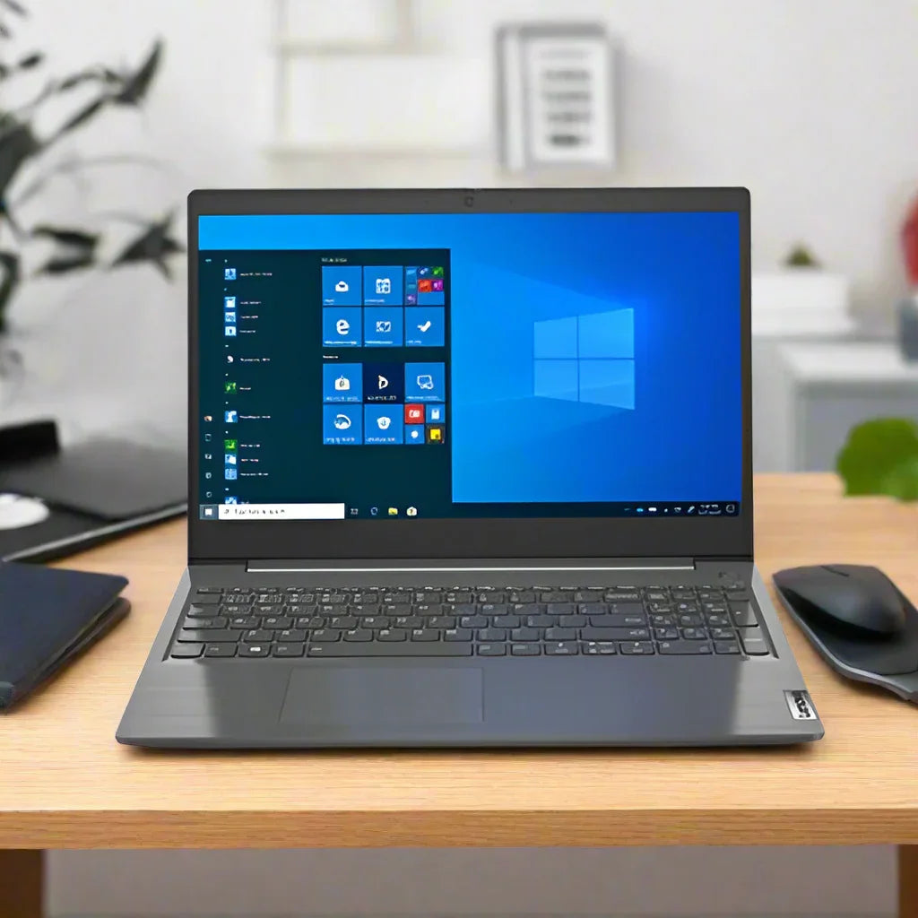 A gray Lenovo V15-IIL i5 1035G1 laptop with 8GB RAM and 256GB SSD runs Windows 11 Pro, displayed on a wooden desk beside a black mouse and closed notebook, with office items and a plant blurred in the background.
