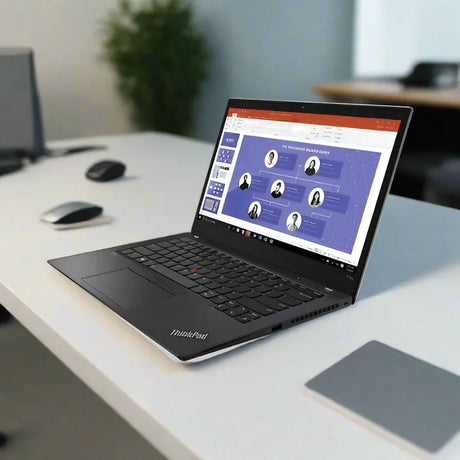 A refurbished Lenovo ThinkPad T14S G2 Ryzen 5 Pro 5650U with Windows 11 Pro sits on a white desk, displaying an organizational chart in PowerPoint, surrounded by office supplies and other desks.