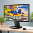 A certified refurbished Viewsonic VG2228wm 22 1920x1080 LED monitor (no stand) on a desk displays three vibrant birds with colorful feathers against a surreal digital background, with a keyboard nearby.