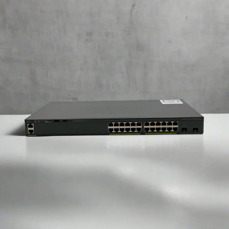 A refurbished Cisco WS-C2960X-24TD-L 24-port Gigabit switch with 2 x 10G SFP+ ports is displayed on a white surface against a plain, light gray background.
