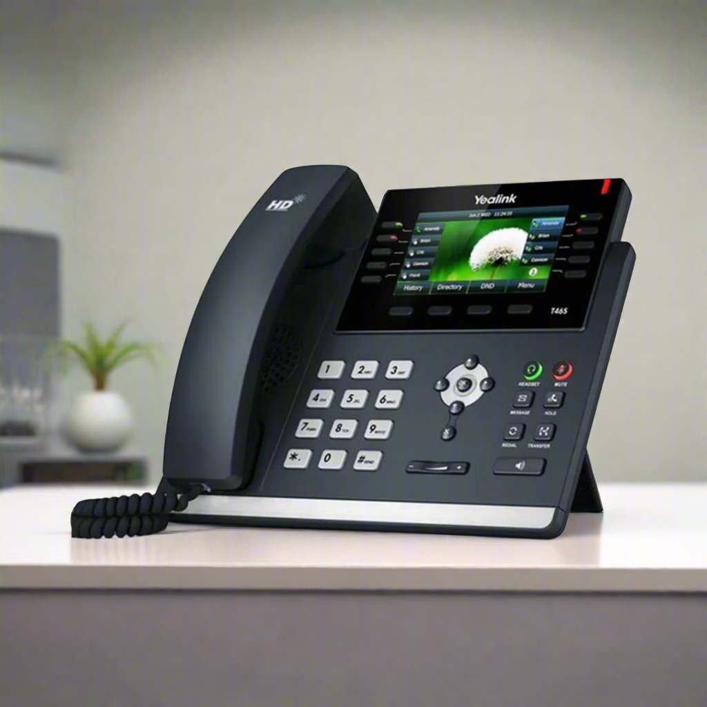 The Yealink SIP-T46S Gigabit IP Phone + Adapter | Wty by Yealink features a corded handset and color display, shown on a light desk in a blurred office setting, ideal for enhanced business communication.