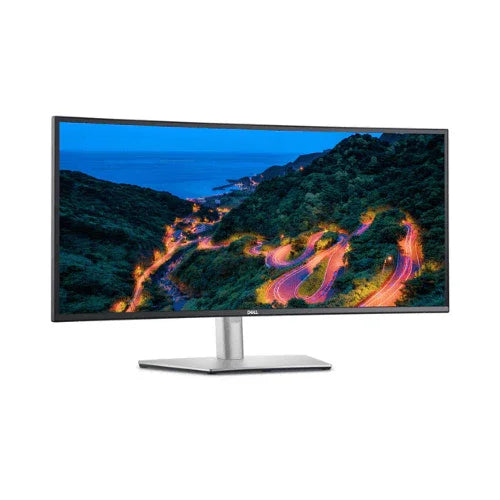 A refurbished Dell U3421WE 34" Curved IPS monitor displays a vivid landscape with a winding road through green hills to the ocean under a blue sky in sharp 3440x1440 resolution.