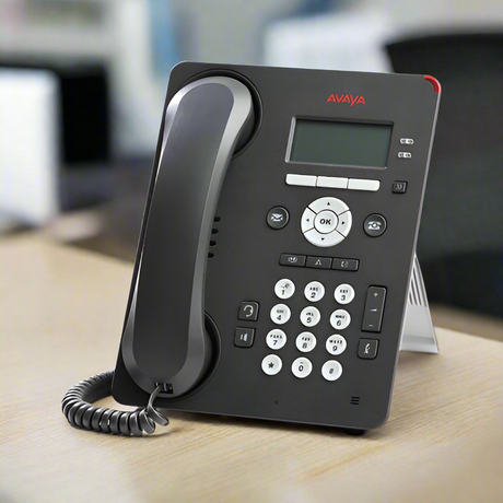 A certified refurbished Avaya 9608G IP Telephone (Part ID: 700419195) with handset and stand by Avaya sits on a light wooden surface. It features a digital display, keypad, and coiled cord—ideal for upgrading your office communications.