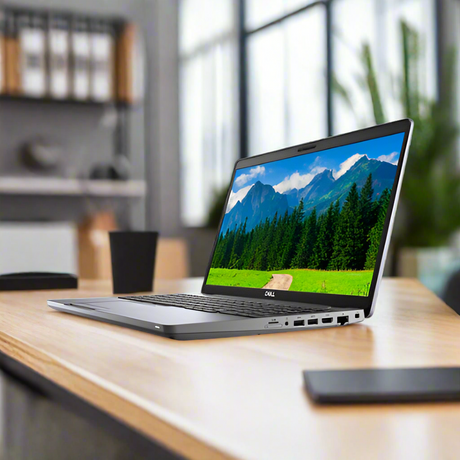 A Dell Latitude 5511 i7-10850H 2.7GHz 32GB 512GB SSD 15.6" W11P | Wty certified refurbished laptop from Dell sits open on a wooden desk in a modern office, displaying a scenic mountain wallpaper with blurred office shelves behind.