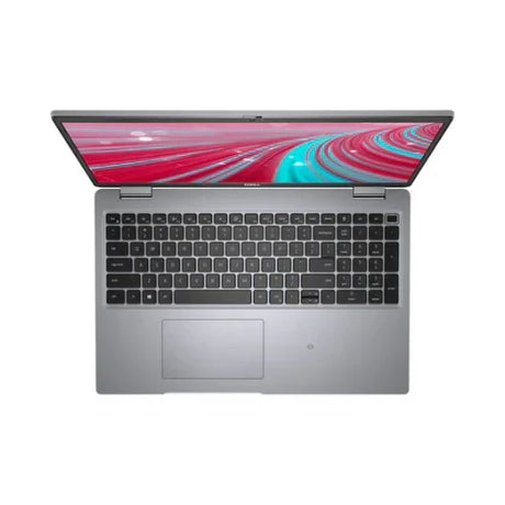 A refurbished Dell Latitude 5521 business laptop with a 15.6" screen, Intel i7-11850H processor, 32GB RAM, and 1TB SSD is shown from above with its keyboard and large touchpad visible, displaying a vibrant abstract design.