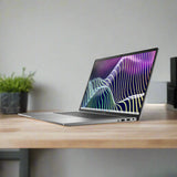 A certified refurbished Dell Latitude 7640 i7-1370P (5.2GHz, 32GB RAM, 1TB SSD, 16" FHD+, Windows 11 Pro) sits open on a wooden desk showing a colorful abstract display, with a green plant in a black pot nearby against a beige wall.