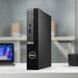 A black Dell OptiPlex 5000 Micro i5 12500T business desktop stands vertically, showing its front panel with power button, USB ports, headphone jack, ventilation grille, and Dell logo. Specs: 16GB RAM, 256GB SSD, WiFi, Windows 11 Pro.