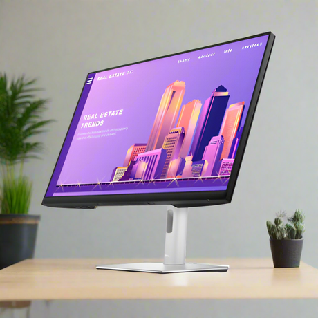 A Dell Professional P2722H IPS 27 monitor (1920x1080, HDMI/DP/VGA/USB, no stand) sits on a wooden desk, displaying a colorful real estate site with illustrated skyscrapers. Nearby are potted plants and a green plant in the background.