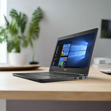 A refurbished Dell Latitude 5480 with Intel Core i5-7200U, 8GB RAM, and 256GB SSD runs Windows 10 Pro, shown on a light wooden desk with blurred plant and decor in the background.