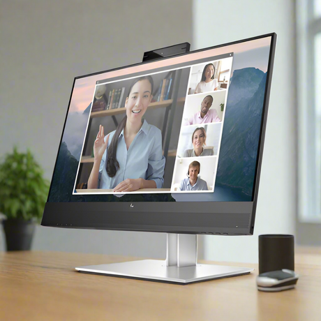 An HP E24mv G4 IPS 23.8 monitor on a desk shows a video call with four people—the main speaker, a smiling woman gesturing, and three others in small windows. A plant and mouse are beside the HP display (no stand included).