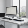 A modern office desk features a monitor with a spreadsheet, laptop, mouse, small potted succulent, and the HP USB-C Dock G4 L13899-001 (90W, HDMI, 2x DP, Gigabit Ethernet) by HP, with cables connected, near large windows overlooking buildings.