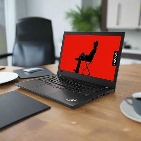 A certified refurbished Lenovo ThinkPad T480 i5 8350U 1.7GHz 24GB 256GB SSD W11P 14" Touch laptop sits open on a wooden desk, surrounded by a cup, saucer, and office supplies. A red screen with a silhouette is displayed.