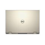 A closed gold Dell Inspiron 7359 2-in-1 i5-6200U laptop is shown from the back, displaying the Dell logo at the center and two hinges at the bottom.