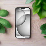 An Apple iPhone 15 Black 256GB (A16 Bionic, FOR PARTS ONLY, Cracked LCD) featuring a minimalist abstract wallpaper rests on a light wooden surface surrounded by green leafy plants.