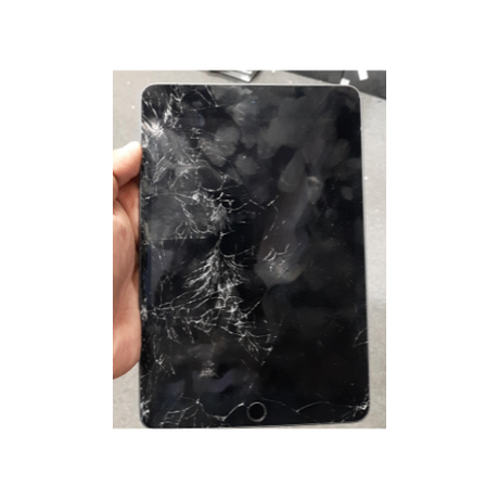 A hand holds an Apple Refurbished iPad Mini 5th Gen 64GB WiFi+Cellular 7.9" Tablet in Space Gray, with a severely cracked and shattered screen marked by spiderweb-like fractures.